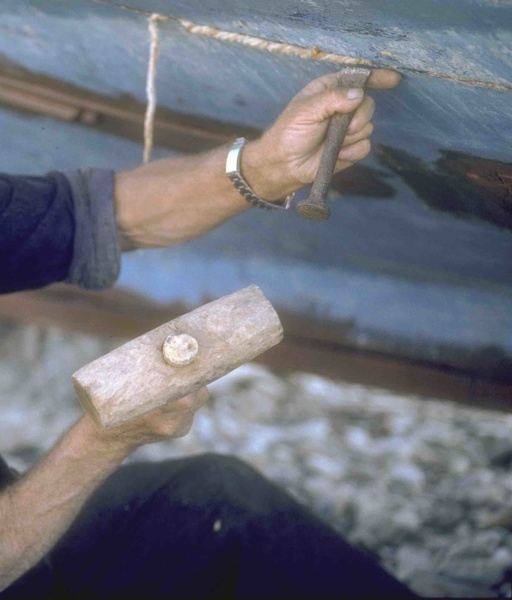Un pecheur calfate son bateau recadre ©Rmoorlag - CC BY 3